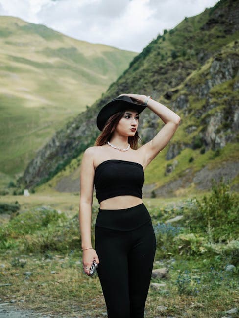 Model in Black Tube Top and Leggings Holding Her Hat