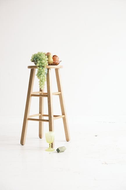 Bowl of Fruits on a Wooden Stool and a Goblet on the Floor