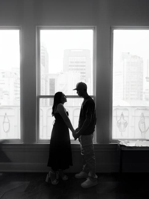 Silhouette of Couple Holding Hands by Window