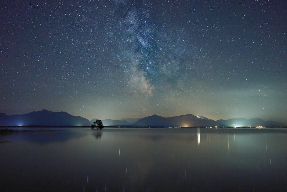 The milky way over a lake with mountains in the background