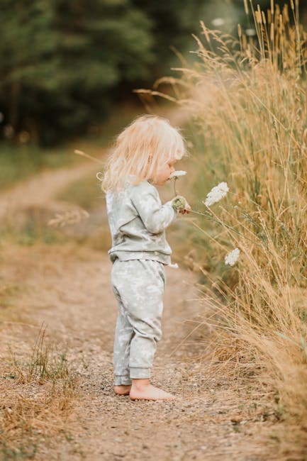 Girl Standing with Flowers on Field