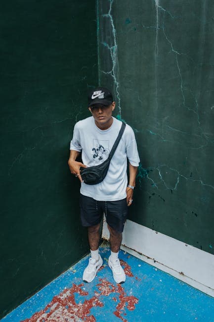 A man standing in front of a wall with a bag