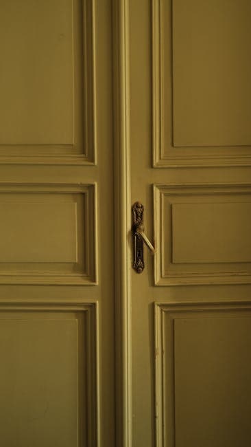 A yellow door with a brass handle and a door knob