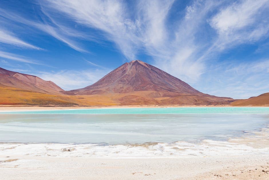 A lake with turquoise water and mountains in the background