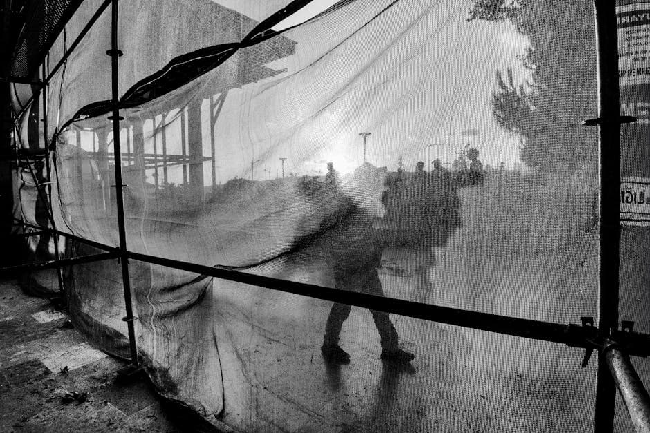 A black and white photo of a person walking through a tent