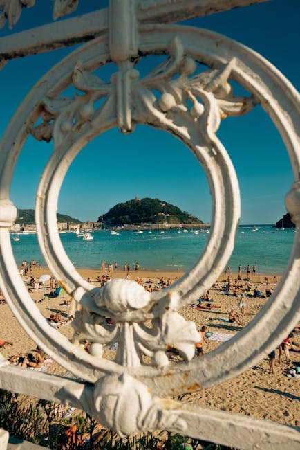 A view of a beach through a wrought iron fence