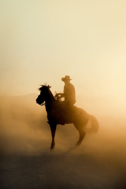 A cowboy riding a horse in the desert at sunset