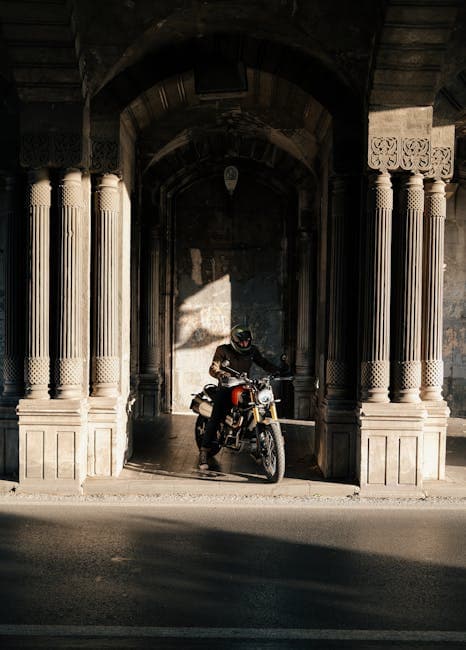 A man on a motorcycle is sitting in the middle of a street