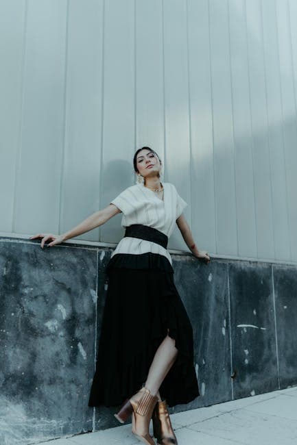 A woman in a skirt leaning against a wall