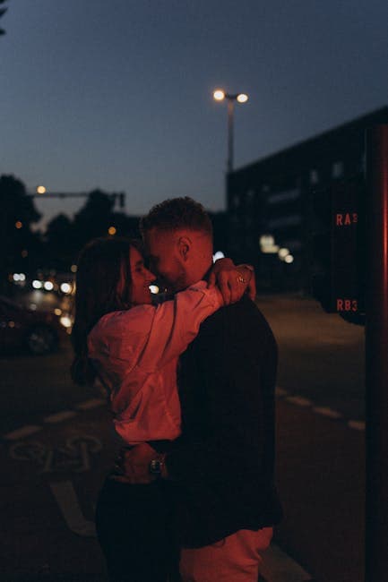 A couple embracing at night in front of a street light