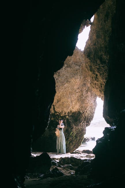 A woman is standing in the middle of a cave