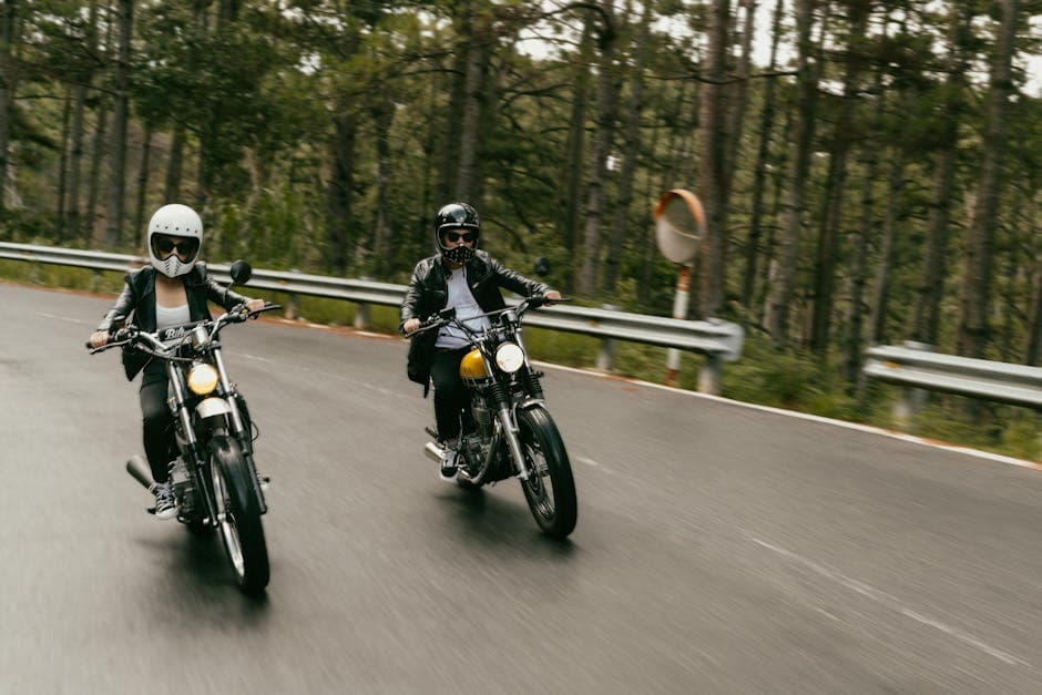 Two people riding motorcycles down a road