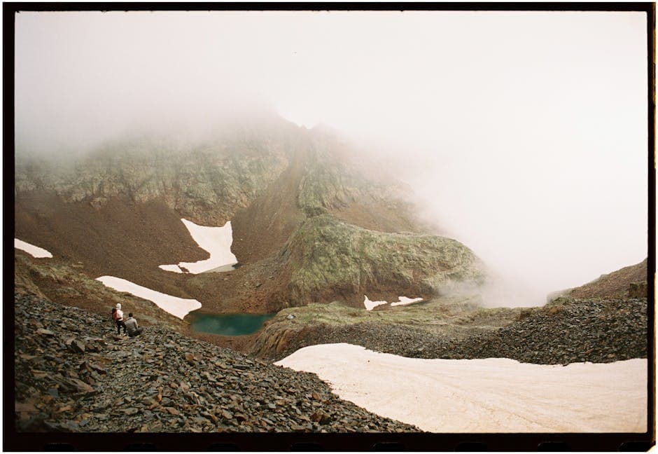 A person standing on a mountain with a lake in the background