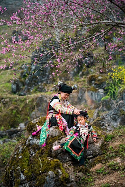 Mother and Daughter in Traditional Clothing Sitting on Rocks