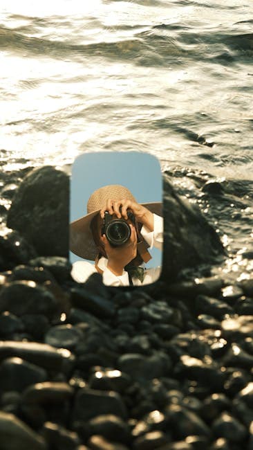 A person taking a photo of the ocean with a camera