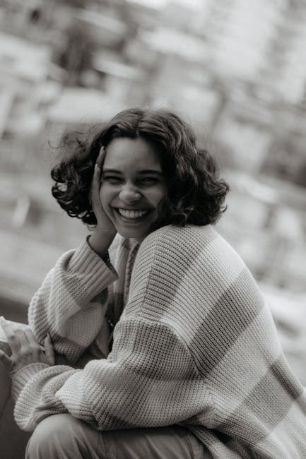 A woman smiling in a sweater and jeans