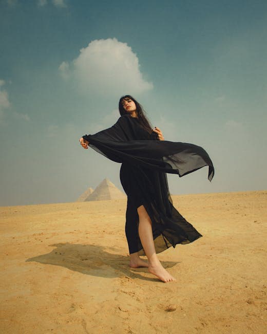 A woman in a black dress is standing in the desert