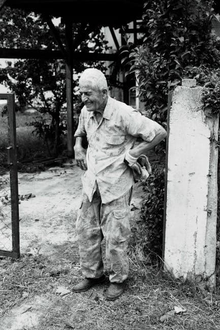 An old man standing in front of a gate