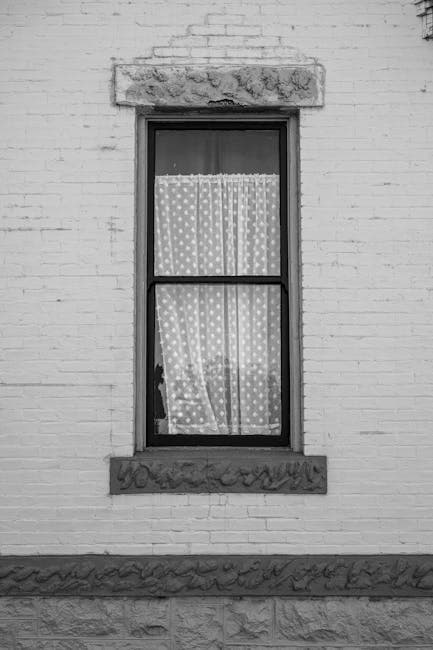 Black and white photograph of a window with curtains