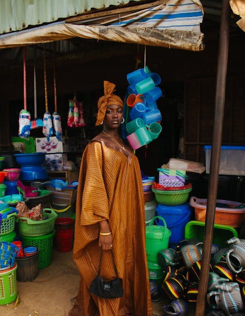 A woman in a brown dress stands in front of a market