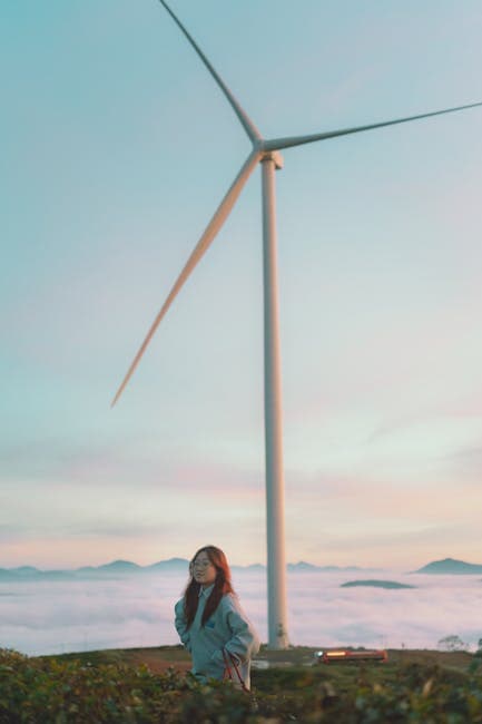 A woman standing in front of a wind turbine