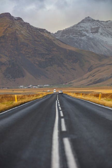 A long empty road with mountains in the background