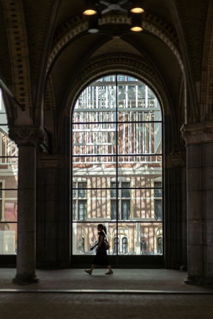 Woman Walking under Arch of Building in Amsterdam