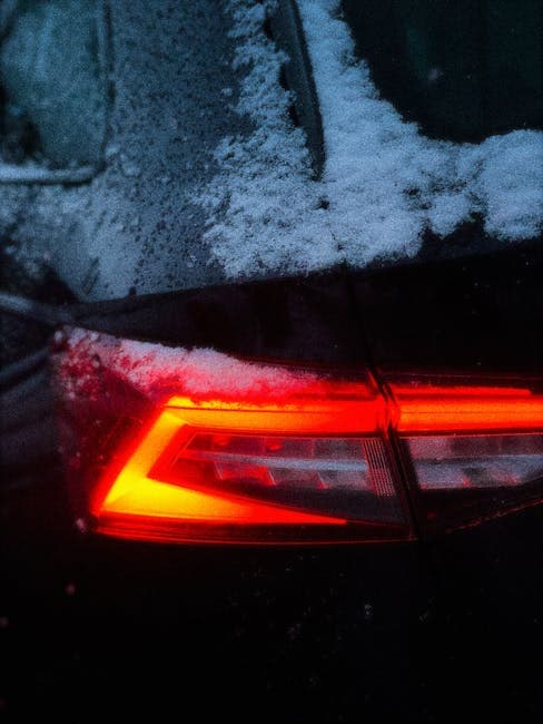 A close up of a car's tail light in the snow