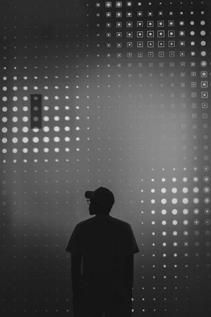 Silhouette of man standing in front of a wall of dots