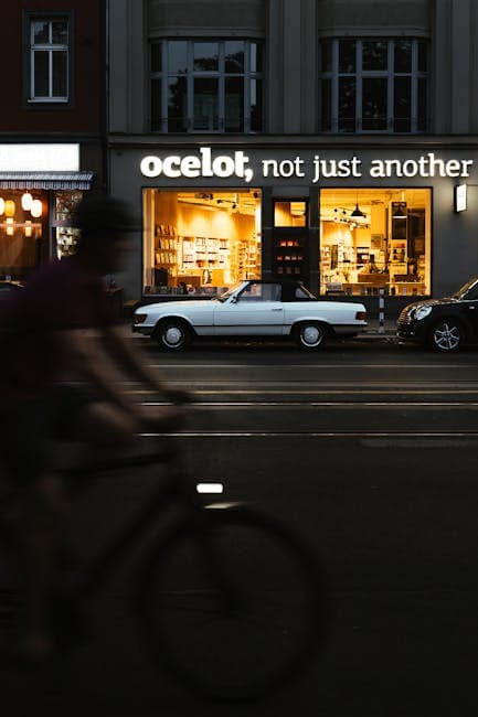 A man riding a bicycle past a sign that says ocok not just another