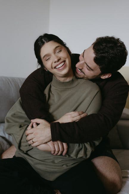 Couple hugging on couch in living room