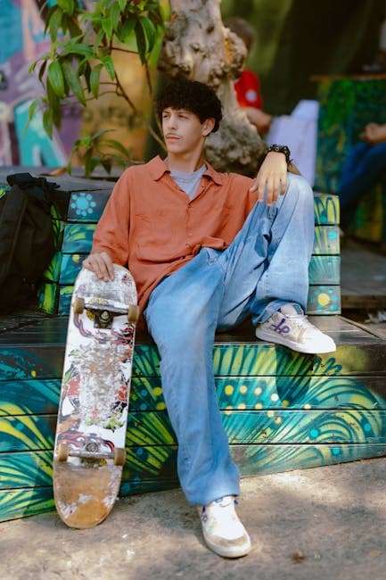 A young man sitting on a bench with a skateboard