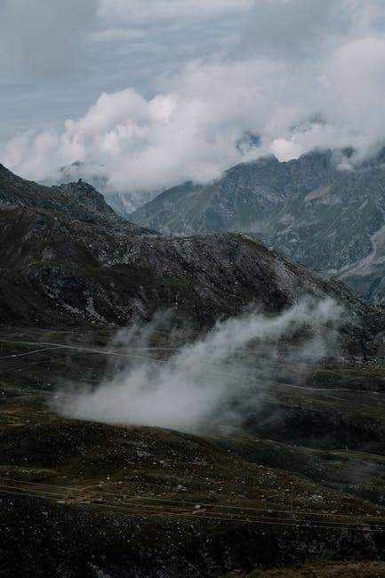 A mountain range with clouds and mist in the distance