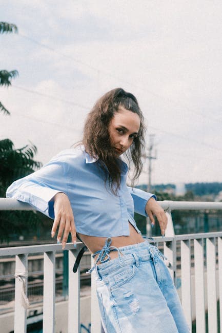 Woman in Blouse and Jeans Leaning on Railing