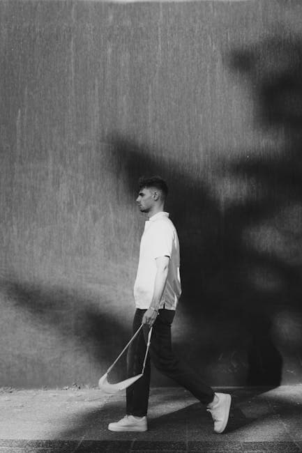 Man in White Shirt and Sneakers on Sidewalk