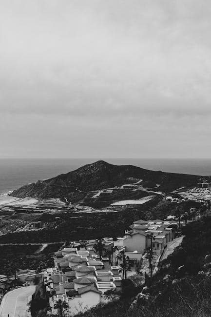 Aerial View of a Town and a Hill on the Shore 