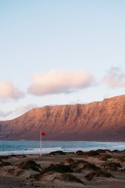 Flag on Beach with Cliff Rocks behind