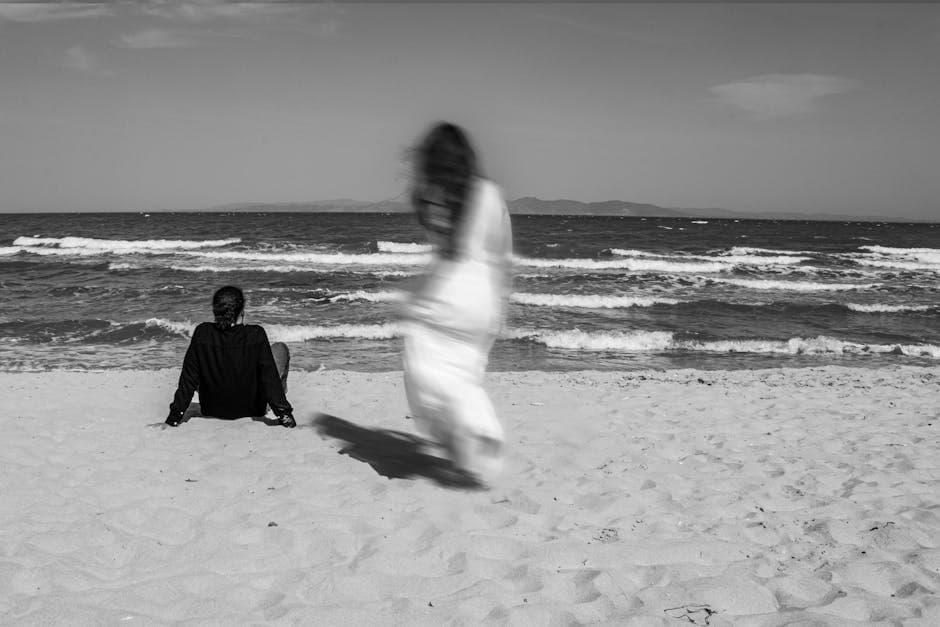 Woman Walking Towards Sitting Man on Beach