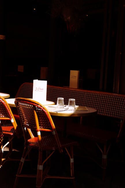 A restaurant with tables and chairs in the dark