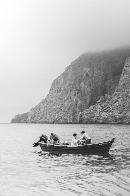 People on Motorboat on Seashore in Black and White