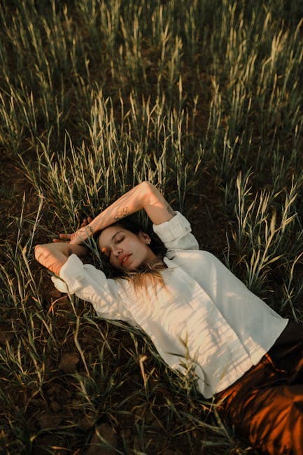 A woman laying in a field of tall grass