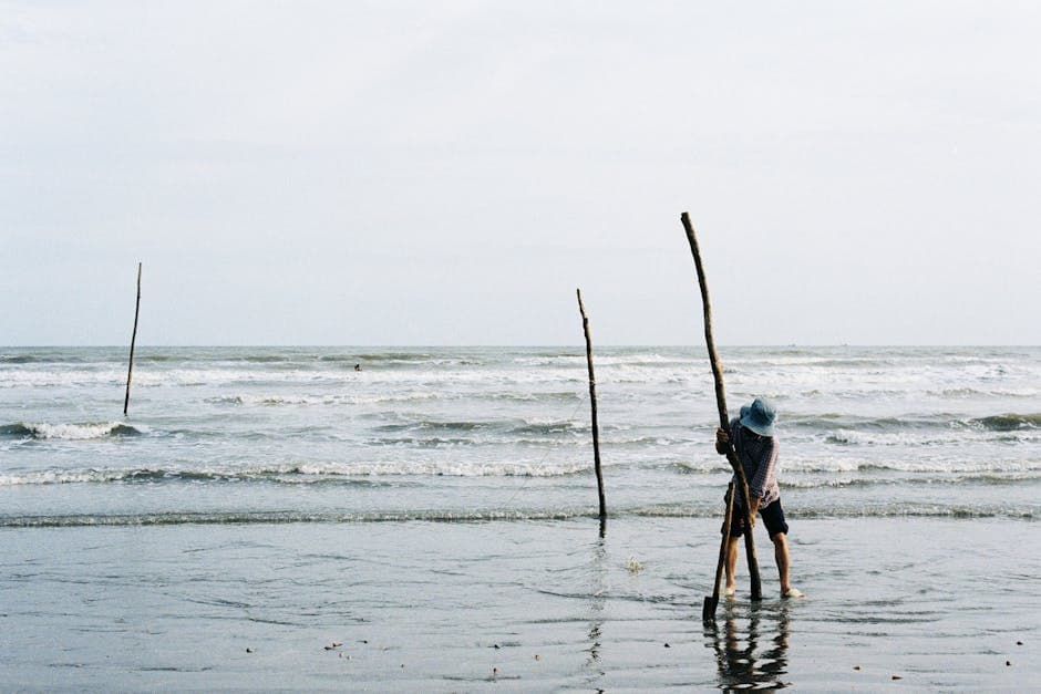 Person Walking with Sticks in Ho Chi Minh Beach