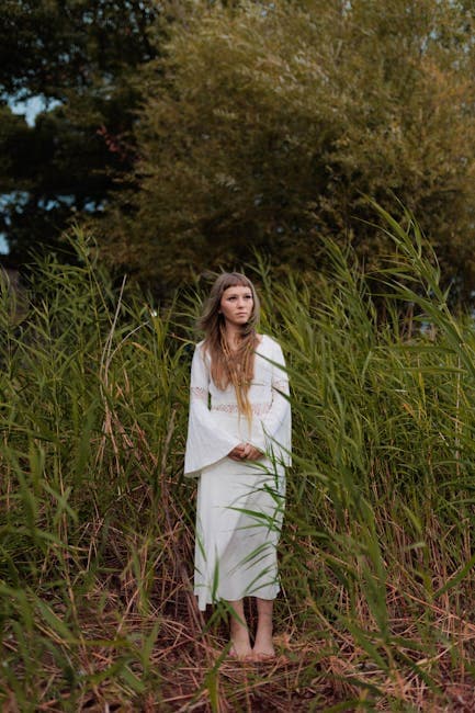 Woman in White Dress Amid Tall Green Grass Outdoors