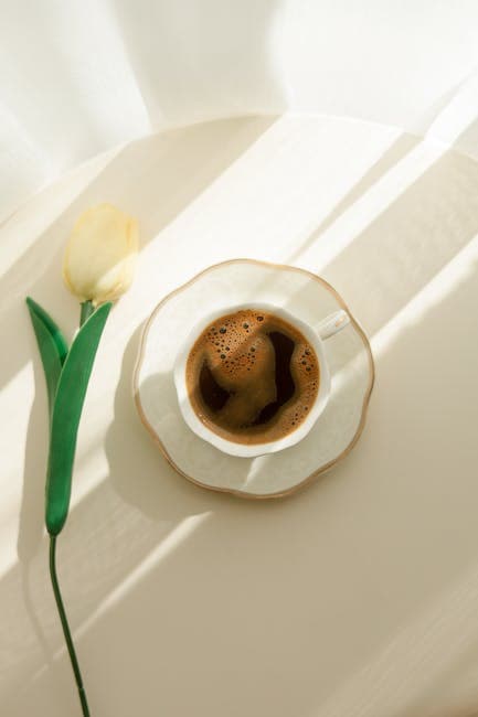 Elegant Coffee Cup with Yellow Tulip on Table