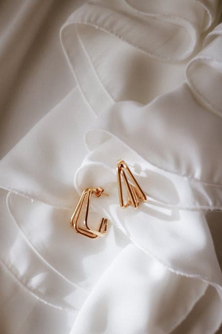 Elegant Gold Earrings on White Silk Fabric