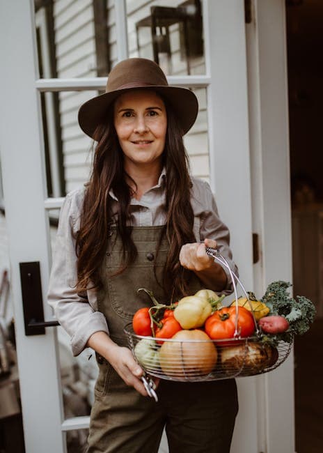 Woman gardener holding wash basket full of harvested vegetables from her garden